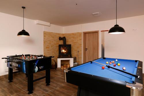 a living room with two pool tables and a fireplace at Apartmány pod Mariánskými schody in Albrechtice v Jizerských horách