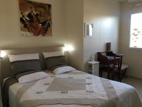 a bedroom with a bed and a chair and a window at La Roseraie résidence près de Vichy in Charmeil