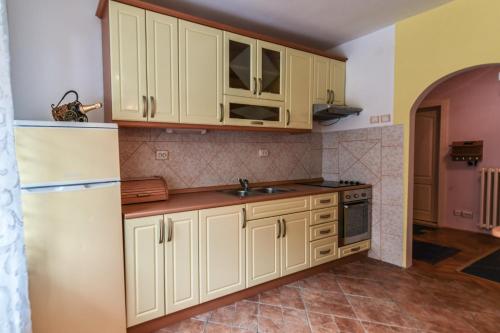 una cucina con armadietti bianchi e frigorifero bianco di Lux Apartman Cvetkovic a Kraljevo