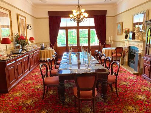 a dining room with a long table and chairs at Bli Bli House Riverside Retreat in Twin Waters