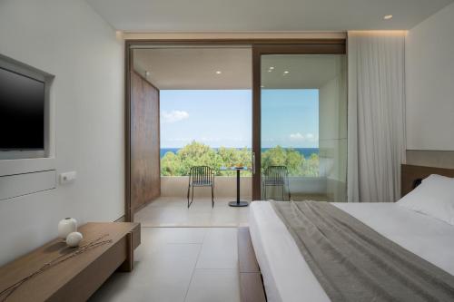 a bedroom with a bed and a tv and a balcony at SanSal Boutique Hotel in Chania Town