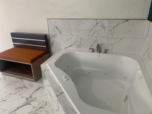a white bath tub in a bathroom with marble walls at Travel Inn Motel in Anaheim