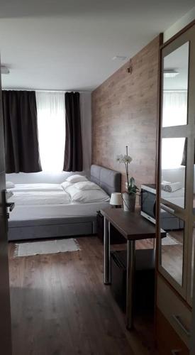 a bedroom with a bed and a table and a mirror at Villa Terrasse in Eger