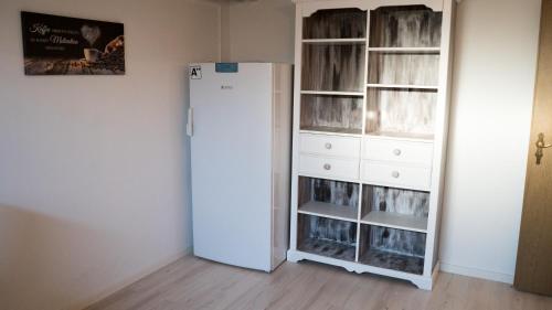 a white refrigerator in a room next to a closet at Work & stay Vohburg near Ingolstadt in Vohburg an der Donau