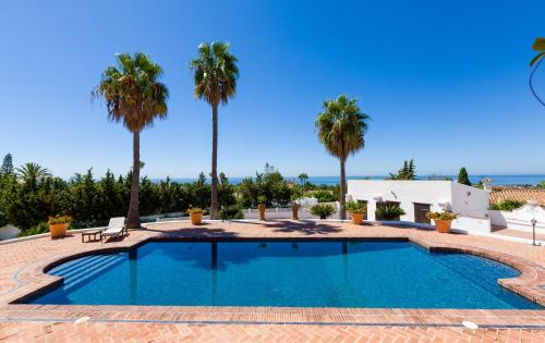 a swimming pool in a resort with palm trees at Cortijo Boutique Marbella in Marbella