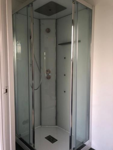 a glass shower stall in a bathroom with a shower at Op de linge in Rumpt