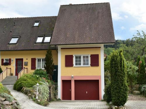 una casa amarilla con garaje rojo en Ferienwohnung Schwalbennest en Badenweiler