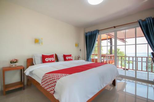 a bedroom with a large bed and a balcony at OYO 1085 Ma Lanta House in Ko Lanta