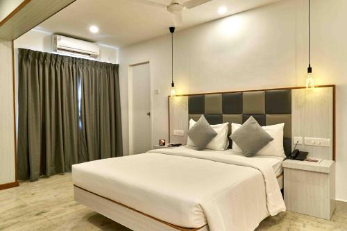 Un dormitorio con una gran cama blanca y una ventana en Hotel Mamallaa Heritage, en Mahabalipuram