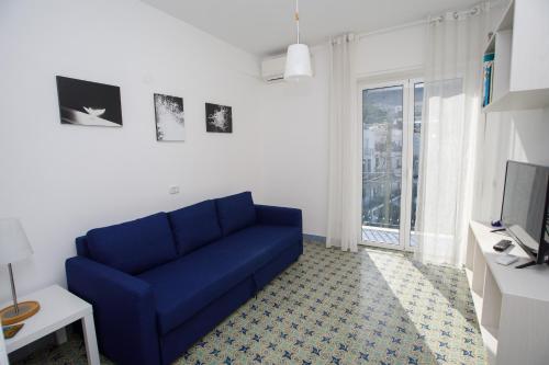 a blue couch in a living room with a window at Capri holiday home with a sea view in Capri