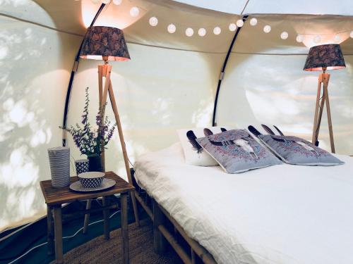 Slite的住宿－Slite Strand resort，帐篷内的一张床位,桌子上放着两盏灯