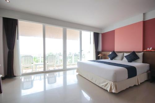 a bedroom with a large bed and large windows at Ananda Lanta Resort - SHA Extra Plus in Ko Lanta
