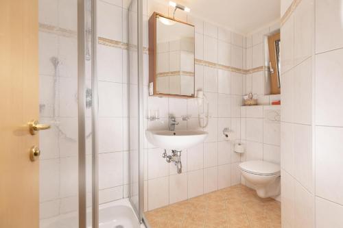 bagno bianco con lavandino e servizi igienici di Edelweiss a Ramsau im Zillertal