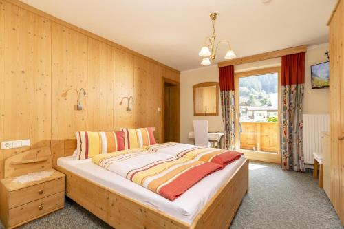 1 dormitorio con 1 cama y pared de madera en Edelweiss en Ramsau im Zillertal