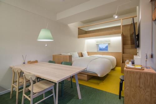 1 dormitorio con 1 cama grande, mesa y sillas en BLO BY BLO HOTEL en Daegu