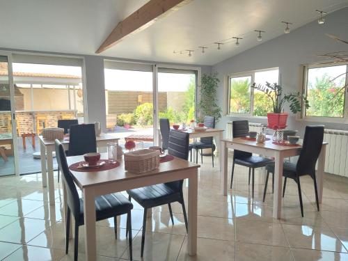 une salle à manger avec tables, chaises et fenêtres dans l'établissement Au Bouchon Champenois, à Bouzy
