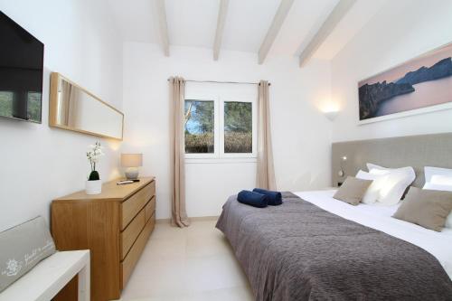 サ・ポブラにあるVilla Albaのベッドルーム1室(ベッド2台、ドレッサー、窓付)