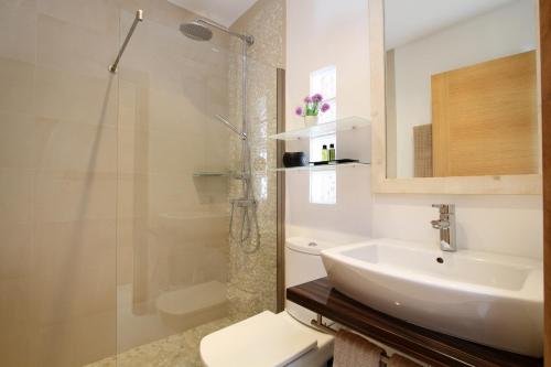 ein Badezimmer mit Waschbecken, Dusche und Toilette in der Unterkunft Villa Alba in Crestatx
