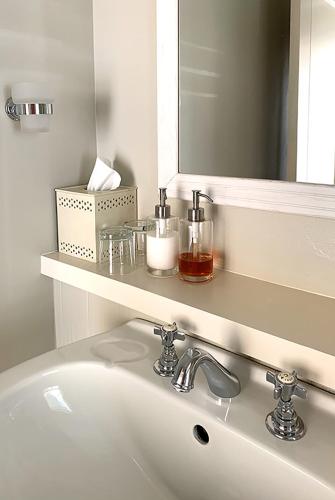 a bathroom sink with a mirror and a white sink at Coral Tree Colony Bed & Breakfast in Southbroom