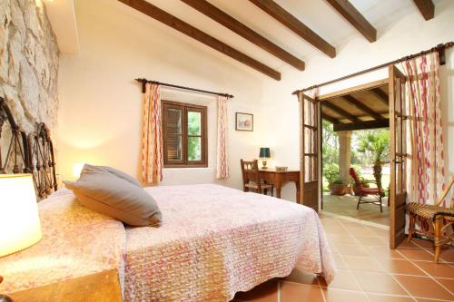 a bedroom with a bed and a table and a patio at El Bikoro in Port de Pollensa