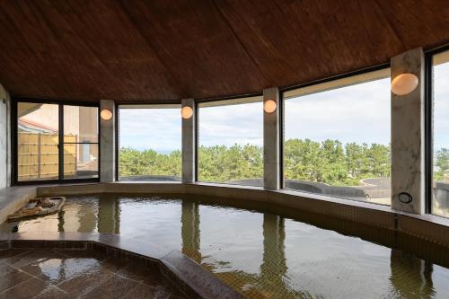 a large pool of water in a room with windows at Hotel Tetora Resort Shizuoka Yaizu in Yaizu