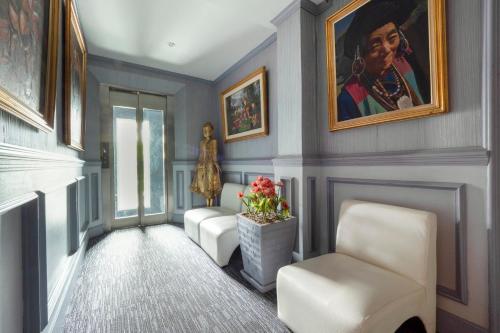 a hallway with two chairs and a painting on the wall at Access Inn Pattaya in Pattaya Central