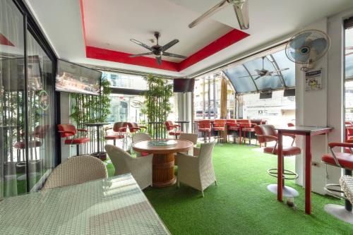 un restaurante con alfombra verde, mesas y sillas en Access Inn Pattaya, en Pattaya central