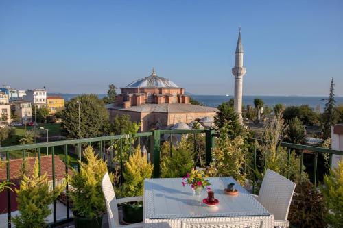 uma varanda com uma mesa e cadeiras e um edifício em Sofia Corner Hotel em Istambul
