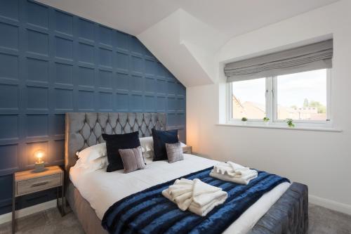 a bedroom with a large bed with a blue wall at Aura Retreat with Free Parking in York