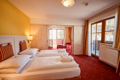 ツァウヘンゼーにあるHotel Enzian by Alpeffect Hotelsのベッド4台と窓が備わるホテルルームです。