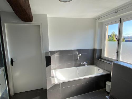 a white bath tub in a bathroom with a window at Authentic Stays - 6p-maisonette in Eijsden