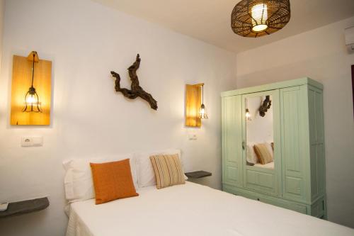 a bedroom with a white bed and a green cabinet at Casa da Orada in Outeiro