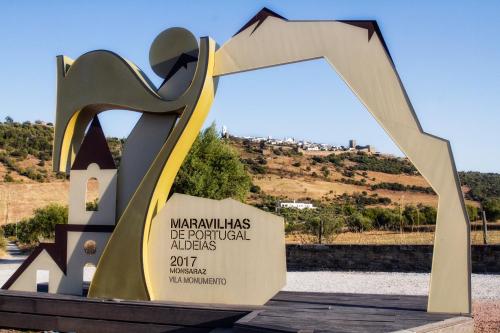 a large metal arch with a sign in front of it at Casa da Orada in Outeiro