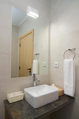 a bathroom with a white sink and a mirror at Casa da Orada in Outeiro
