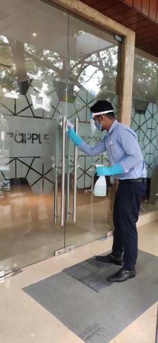 a man standing in front of a glass window at 7 Apple Hotel - Viman Nagar Pune in Pune