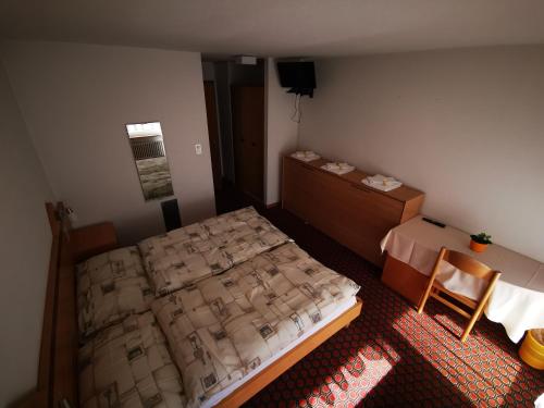 a bedroom with a bed and a chair in it at Hotel Restaurant Aletsch in Mörel