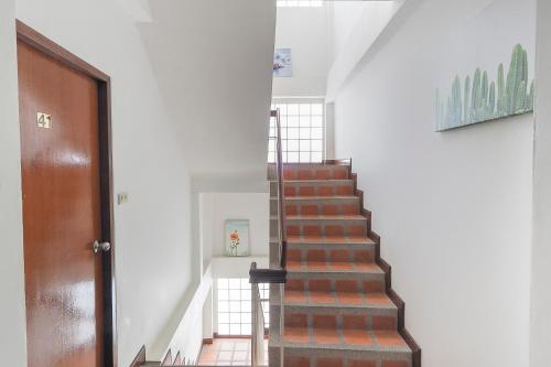 a staircase in a house with a wooden door at Tong Mee House Hua Hin in Hua Hin