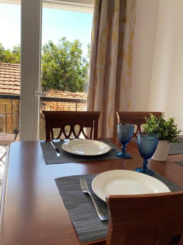 a dining room table with two plates and a window at Cozy place in Larnaka