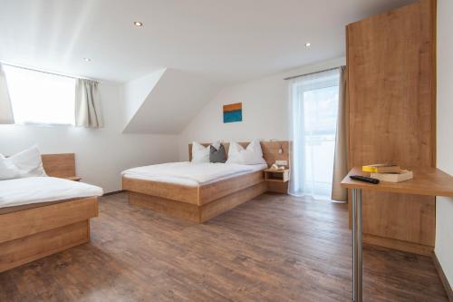 a hotel room with two beds and a table at Appartements Steiger in Bad Hofgastein