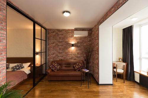 a bedroom with a couch and a brick wall at Апартаменты Азбука на Телецентре (Конгресс-Холл) in Ufa