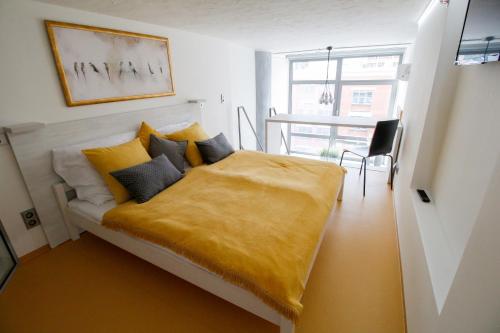 ein Schlafzimmer mit einem Bett mit einer gelben Decke in der Unterkunft Vita Sana Apartments&SPA - Family loft in Zlín