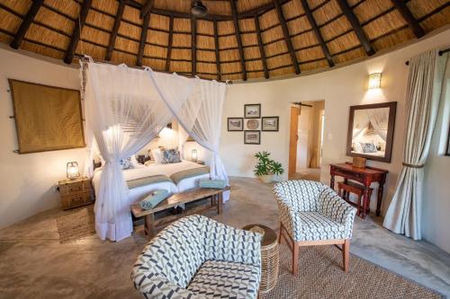 a bedroom with a bed with a mosquito net at Nyala Safari Lodge in Hoedspruit