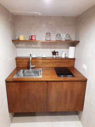 eine Küche mit einem Waschbecken und einer Arbeitsfläche aus Holz in der Unterkunft IL BASSO ACCOMODATION in Neapel