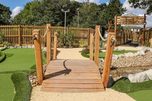a wooden walkway in a garden with a wooden fence at China Fleet Country Club in Saltash