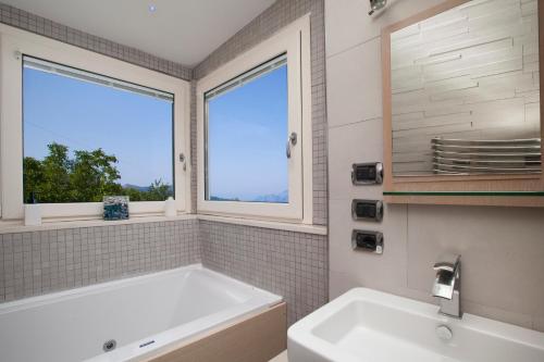 baño con bañera, lavabo y ventana en Villa Ieisha en Massa Lubrense
