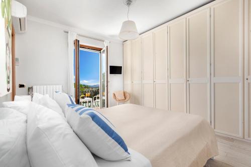 a bedroom with a bed with white and blue pillows at Villa Ieisha in Massa Lubrense