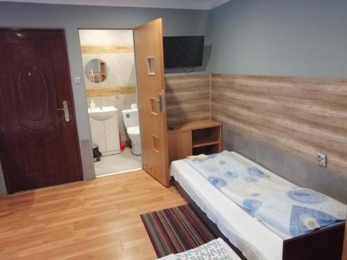 a small room with a bed and a bathroom at Pokoje Gościnne Polo in Częstochowa