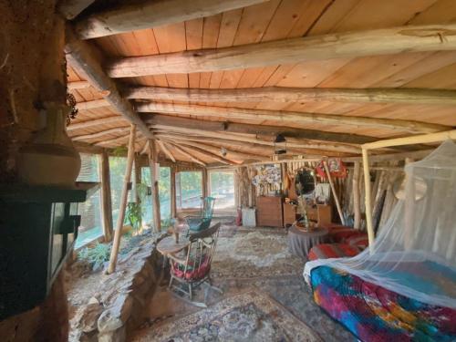 sala de estar con techo de madera y sofá en Hobbit house, en Ripanj