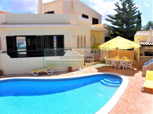 a villa with a swimming pool in front of a house at Villa Catuna - Quinta do Jolu in Guia