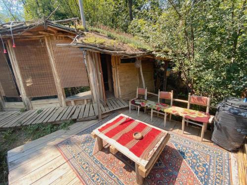 un porche de una casa con mesa y sillas en Hobbit house, en Ripanj